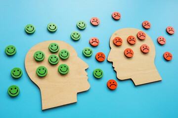 Heads with negative and positive emoticons. Resilience and emotions concept.