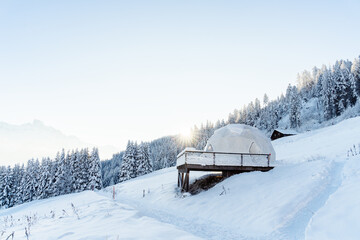 Whitepod winter igloo hotel in swiss mountauns covered by white snow at sunrise at morning. Luxury...