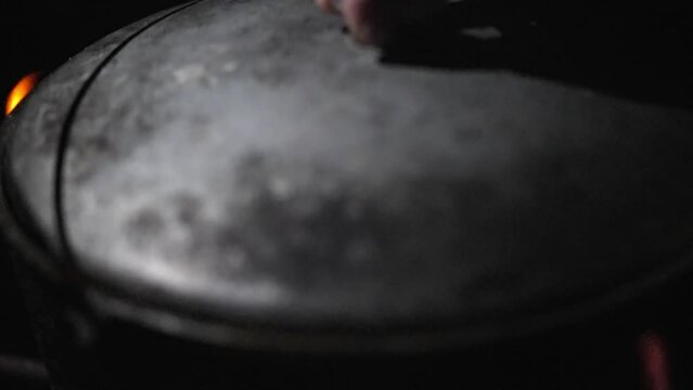 The contents of the cauldron with food cooked on the fire