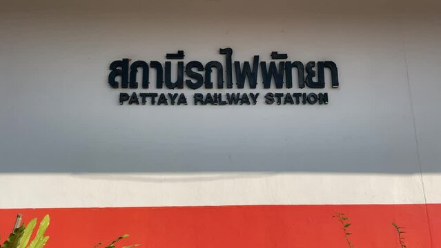 Pattaya railway station sign on the wall sunny day tilt up shot. Transportation concept, Thailand