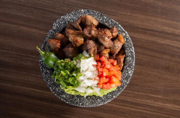 Chicharrón de cerdo con tomate, cebolla y chile en molcajete.