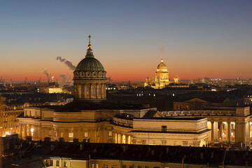 Fototapeta premium Russia, St. Petersburg, Domes of Cathedrals over the roofs of houses against the backdrop of the sunset sky