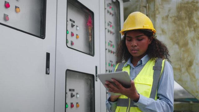 Worker woman or Industry maintenance engineer female dark skin wearing uniform and safety helmet under inspection and checking process on construction site.Industry,civil Engineer,construction - Powered by Adobe