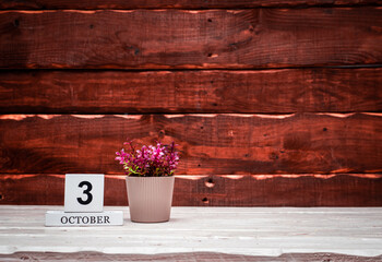 October calendar with number  3. Planner copy space on a wooden brown background. March number icon. Place for text background calendar