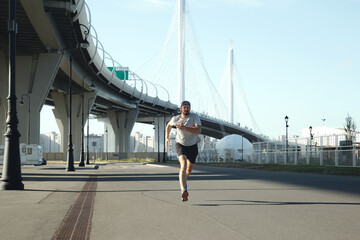 Man running in front of a bridge
Man