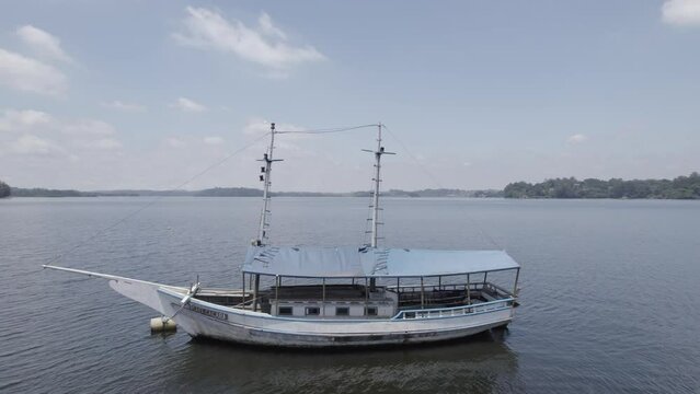 Drone atravessando o mastro de um barco na represa