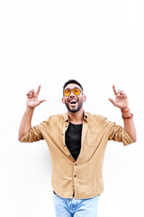 Naklejka premium smiling happy young Hispanic-Latino ethnic pointing with both hands upwards on white isolated background. copy space for text. vertical photograph.