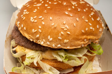 closeup of sloppy assembled or cooked Bigmac burger taken away from McDonalds restaurant