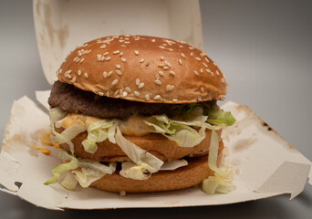 closeup of sloppy assembled or cooked Bigmac burger taken away from McDonalds restaurant