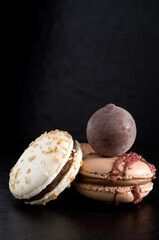 Close-up of Delicious Chocolate Macarons and Chocoalte Ball on Dark Background