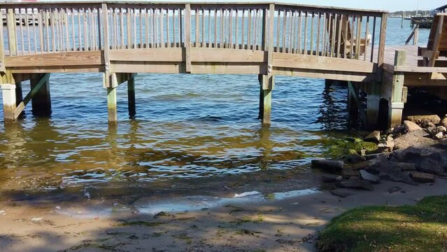 Small Waves Passing By Under Wooden Bridge With rocks