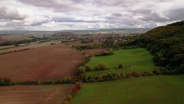 Aer ial view of a German village surrounded by meadows, farmland and forest in Germany.