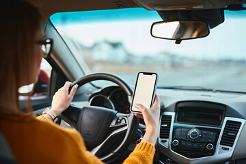 woman driver using mobile phone screen blank mockup on the road while driving a car