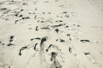 Messy footprints in the sand at the beach, background.