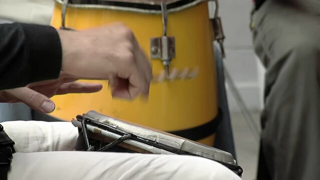 Latin Percussionist Playing a Drum using his Hands and Stick. Close Up. 