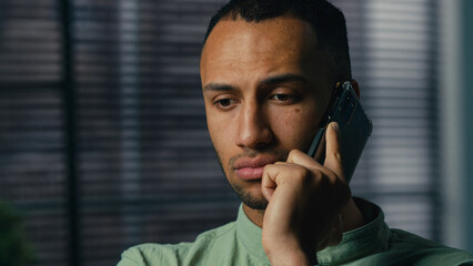 Serious worried excited latin american man talking mobile phone sad frustrated confused young...