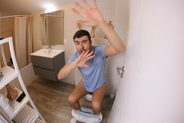 Embarrassed man caught in the toilet  - obrazy, fototapety, plakaty