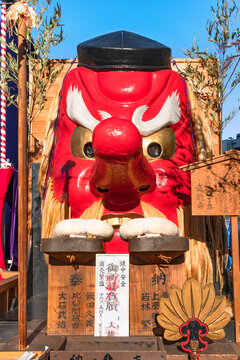 tokyo, setagaya - february 01 2023: Giant vermilion face of a Japanese folklore supernatural creature with a long nose called Tengu exhibited with its attributes at the Shimokitazawa Tengu Festival.