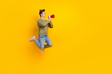 Full length profile photo of carefree active person jumping hold loudspeaker say tell empty space...