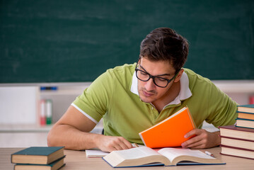 Young male student sitting in the classroom