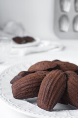 Chocolate madeleines on a ceramic plate, plain chocolate madeleine cake or cookies