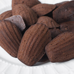Chocolate madeleines on a ceramic plate, plain chocolate madeleine cake or cookies