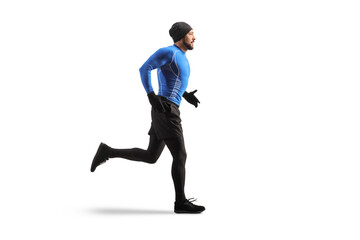 Full length profile shot of a young fit man running in warm clothes