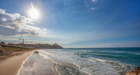 Fototapeta na wymiar Sand beach in Tel Aviv - view on Old Jaffa and Mediterranean Sea