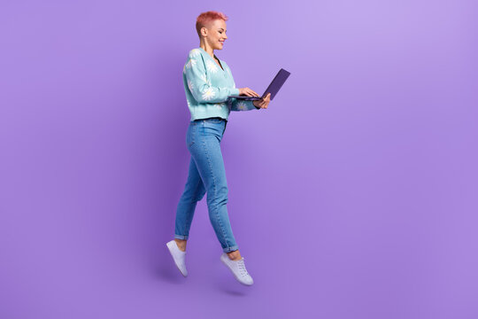 Full body size photo of professional programmer courses teacher woman jump hold netbook writing code python isolated on purple color background