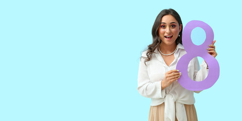 Happy woman holding figure 8 on light blue background with space for text. International Women's Day