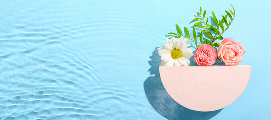 Empty modern podium with flowers in water on blue background with space for text © Pixel-Shot