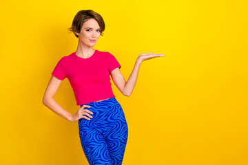 Photo of pretty sweet lady wear pink t-shirt showing holding arm empty space isolated yellow color background