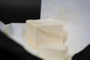 slice of a butter on a paper on table 