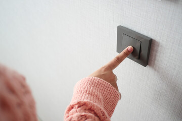  women finger turning on lighting switch .