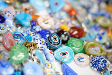 close up of colorful beads on the table. Colorful handcrafted glass necklaces. Variety of shapes and colors to make necklaces