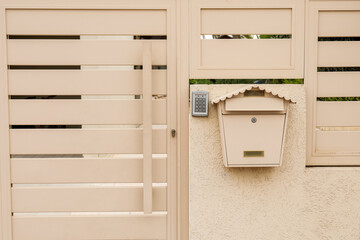 Modern fence with intercom and mailbox outdoors