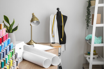 Table with lamp and sewing patterns in modern atelier