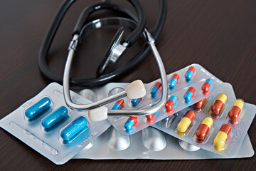 Pharmaceutical pills, throat spray and stethoscope. On a dark background. Medical topics. Close-up