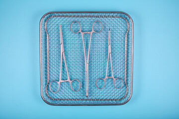Surgical instruments in a tray on a blue