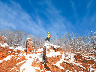 A man standing on rocks on a winter day