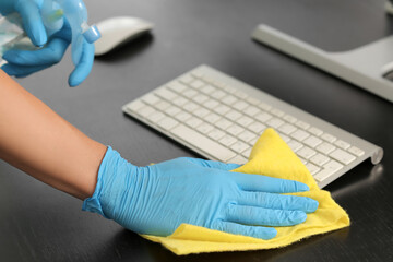 Female janitor cleaning table in office, closeup