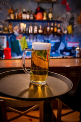 waiter hand and tray with Beer into glass on bar