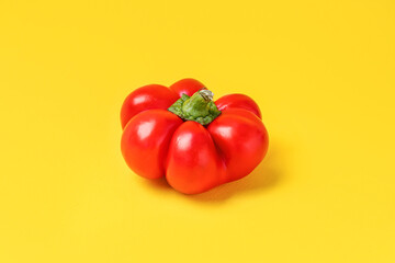 Red bell pepper on yellow background