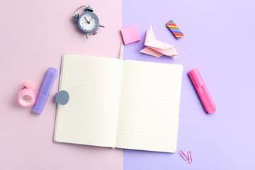 Blank open notebook, different stationery and alarm clock on color background