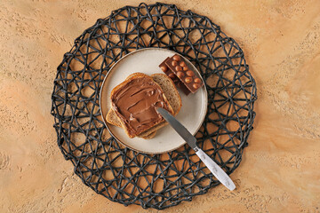 Plate of tasty toasts with hazelnut butter and chocolate on color background - Powered by Adobe