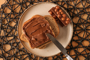 Plate of tasty toasts with hazelnut butter and chocolate on table