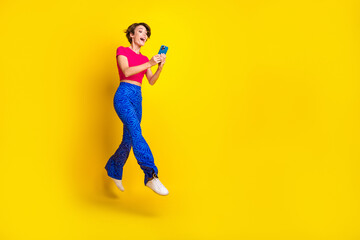 Fototapeta na wymiar Full length photo of positive lady user wear stylish clothes use modern devise video talk empty space isolated on yellow color background
