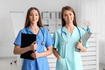 Female medical assistants with clipboards in clinic