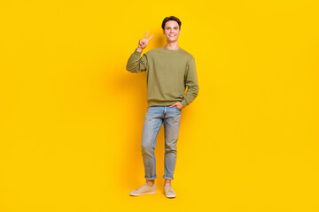 Fototapeta premium Full length photo of positive nice man wear street smart casual style clothes hand v-sign empty space isolated on yellow color background