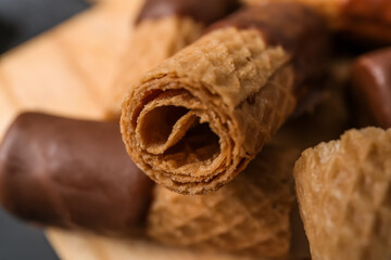 Delicious wafer rolls on grunge background, closeup